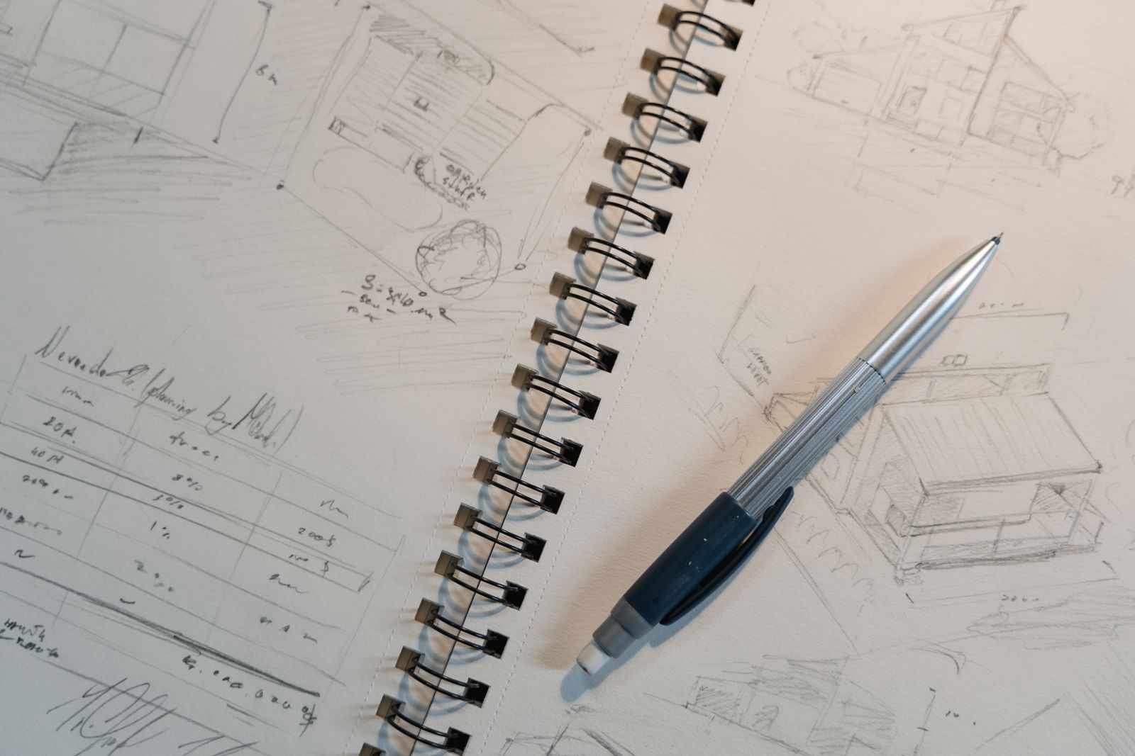 Explore detailed architectural sketches and designs on a spiral notepad with a mechanical pencil.